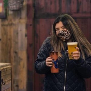 woman holding two glasses of beer