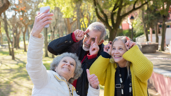 Group of two women and one man taking a selfie