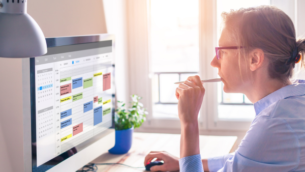 A woman looking at her schedule on her computer. 