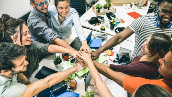 A group of professionals putting their hands together as a team.