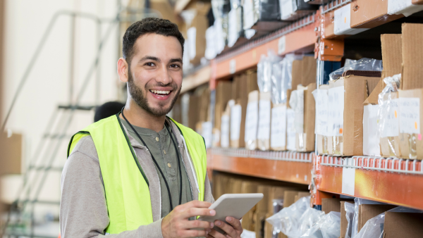 Male employee smiling in a warehouse.