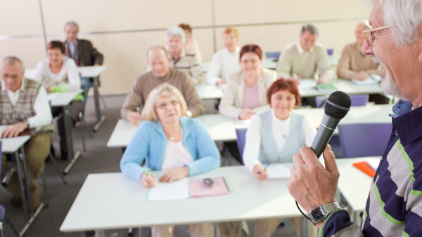 A classroom full of adult learners listening to their instructor's lecture. 