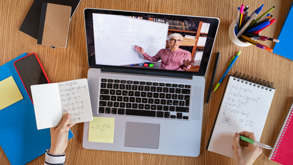 Student taking notes to an online lecture.