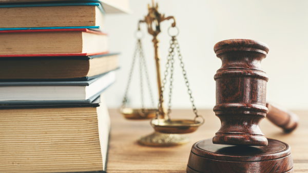 A gavel next to a stack of books. 