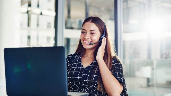 A woman making a phone call on her computer. 