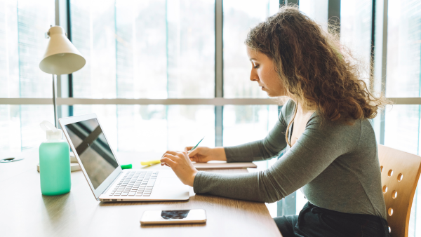 A woman writing on her computer. 